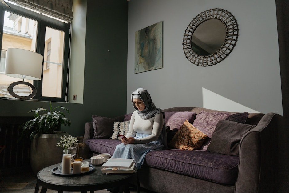 Woman in White Hijab Sitting on Brown Sofa